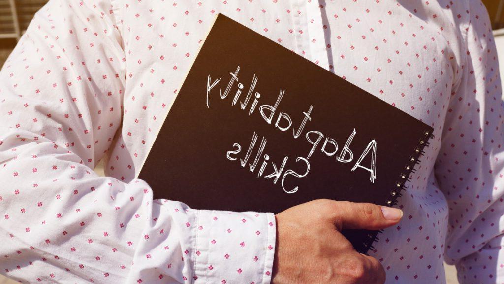 placeholder image of a person holding a binder with the words adaptability skills on it